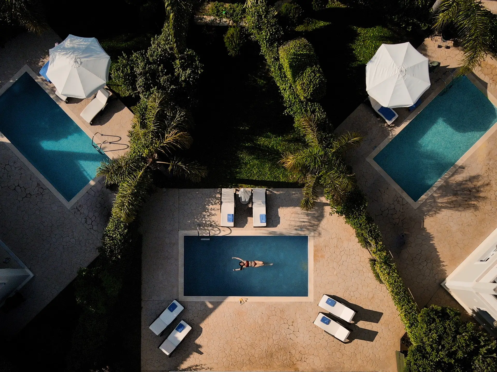 Mamfredas Luxury Resort Aerial Photo of the Pool, where a girl lies on the water in the middle.